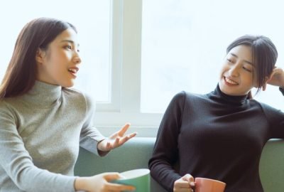two-asian-women-chatting-by-window_296537-2811